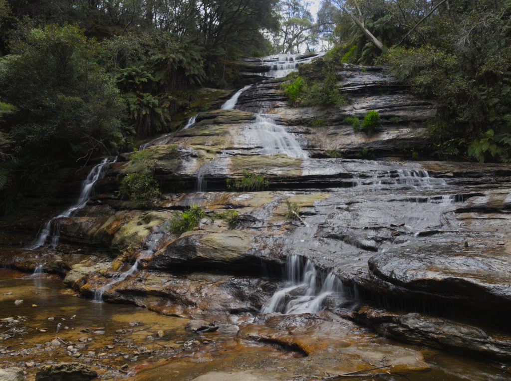 Katoomba Cascades in the Katoomba Falls Reserve is a cascade waterfall flowing over several levels of rock before continuing to Katoomba Falls