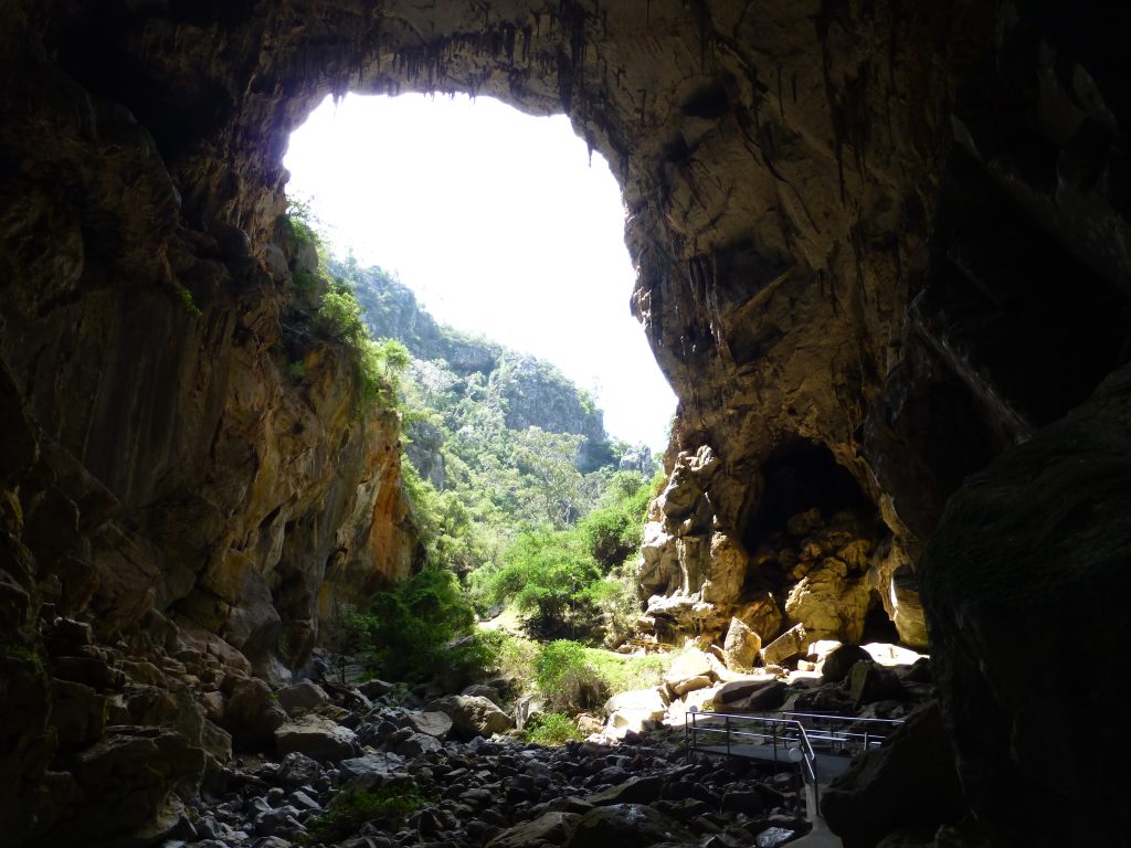 The sky and bushland as seen from within a large cave on one of the hiking trails at Jenolan Caves in the Blue Mountains