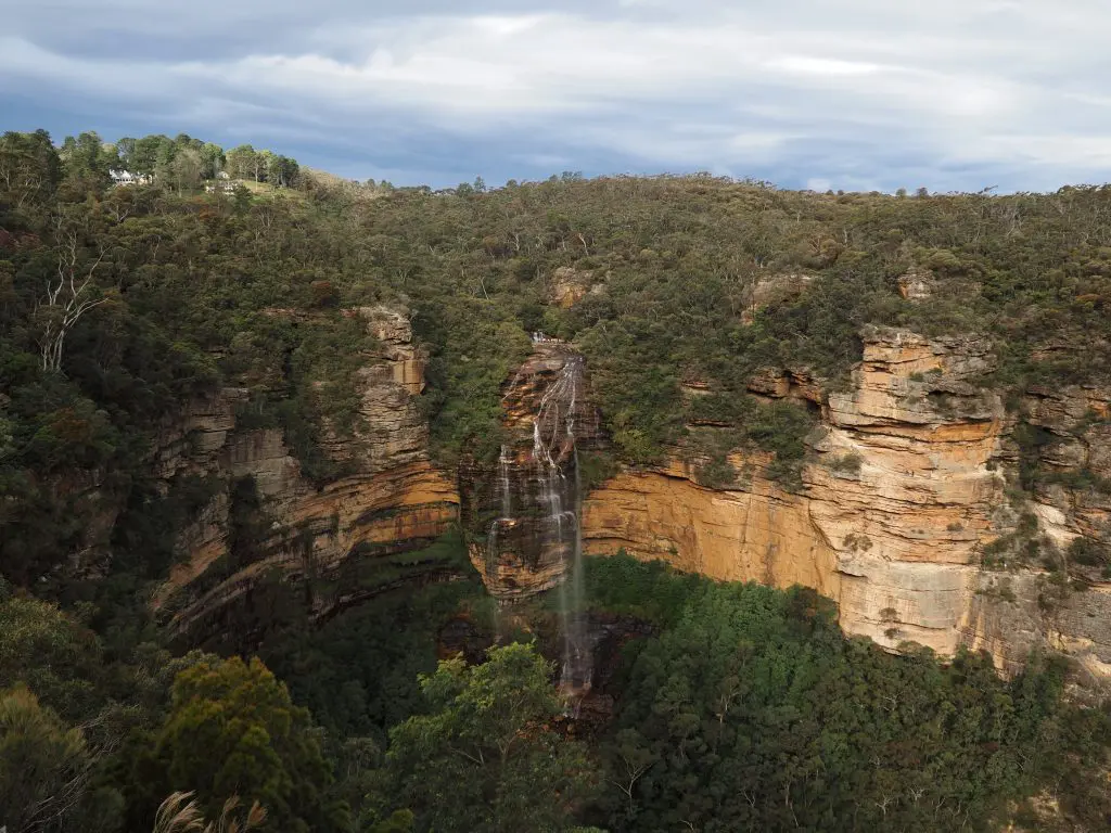 View of Wentworth Falls, a large cascading waterfall flowing over clilffs into the Jamison Valley, from Princes Rock Lookout, Wentworth Falls