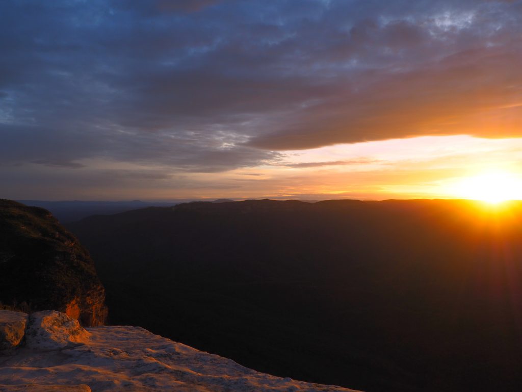 Sun sinking behind the range looking over the Jamison Valley and Mount Solitary from Lincolns Rock in Wentworth Falls