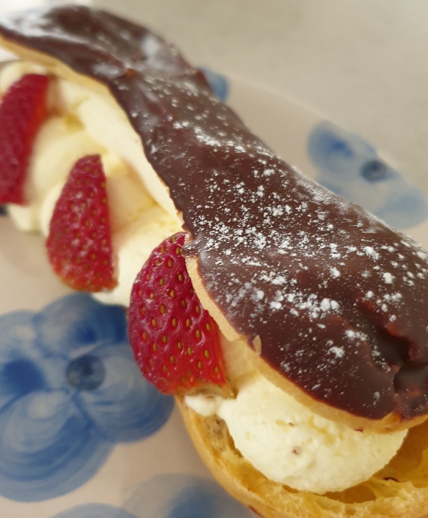 Chocolate Eclair from Schwarzes Bakery in Wentworth Falls. The eclair is filled with fresh cream and fresh cut strawberries.