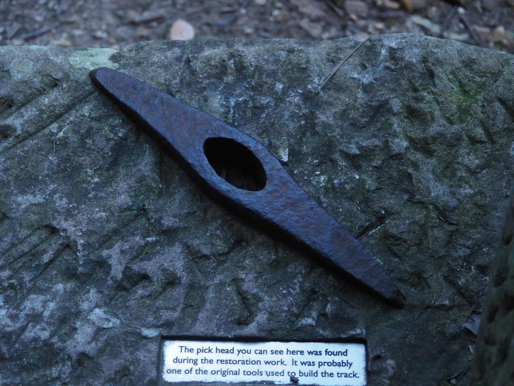 A pick head which was found during restoration of the track and believed to have been used in its original connstruction. It is displayed on a sandstone block. 