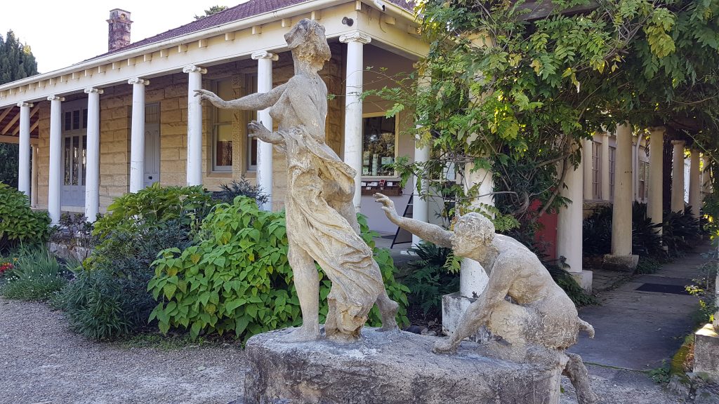 Exterior of the Norman Lindsay Gallery at Faulconbridge. The heritage building is pictured behind a female statue on the lawn