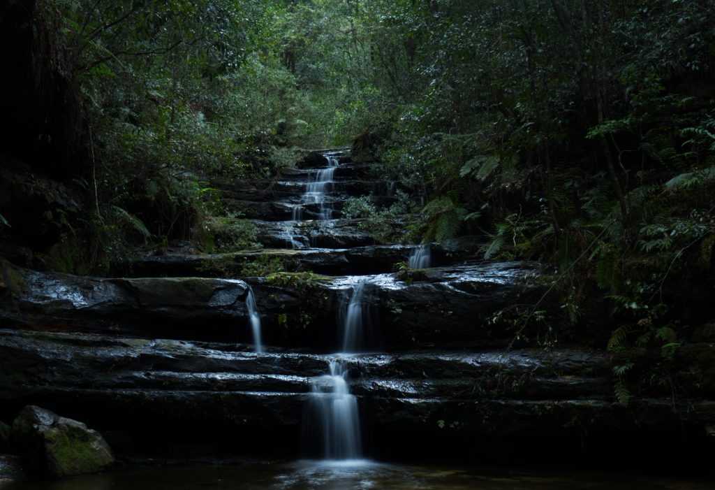 Long exposure shot of Terrace Falls in Hazelbrook, taken front on but back from the falls to show the terrace effect of the rocks